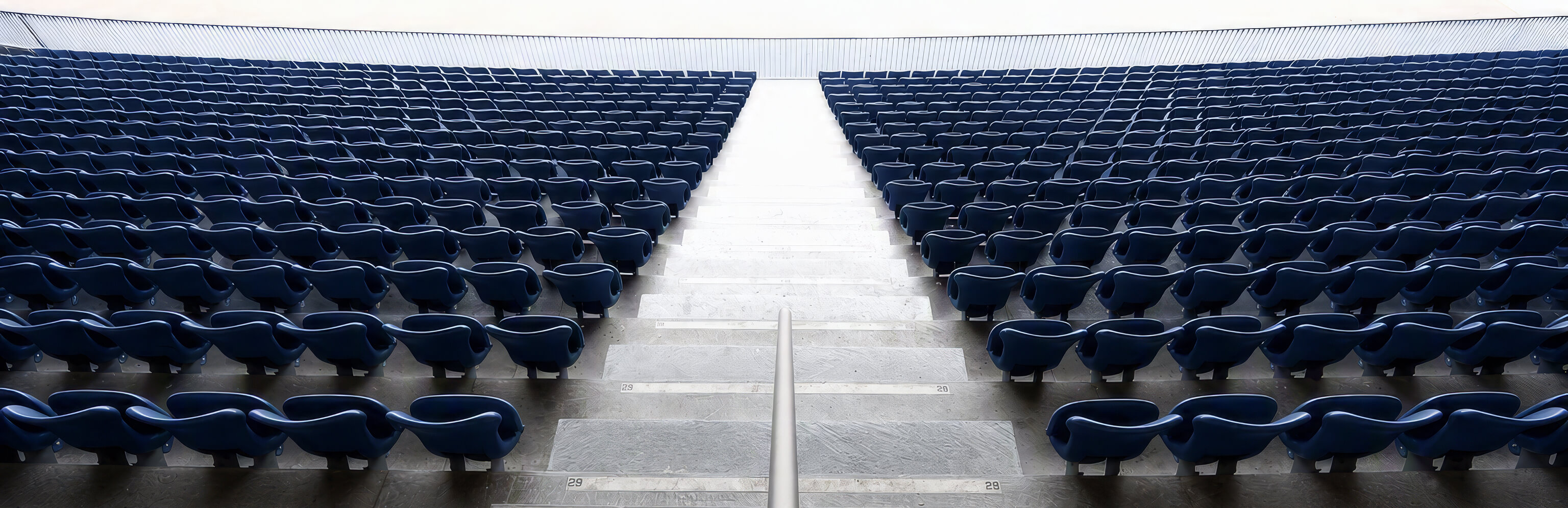 Empty stadium seating symbolizes the inverted wealth lifecycle of professional athletes, who often earn peak income early in life and must sustain it long after their playing careers end.